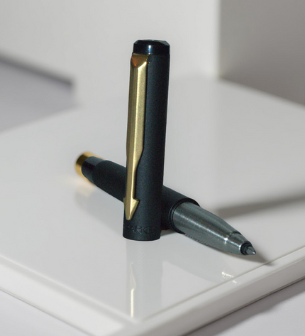 Black and gold pen on a white surface