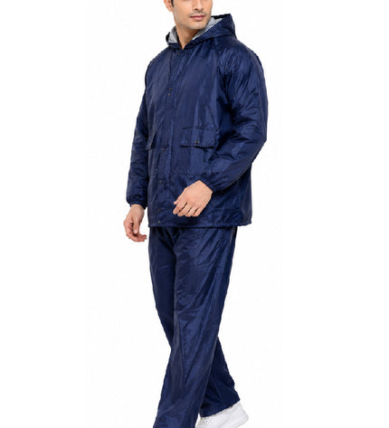 Man wearing a navy raincoat and pants on a white background