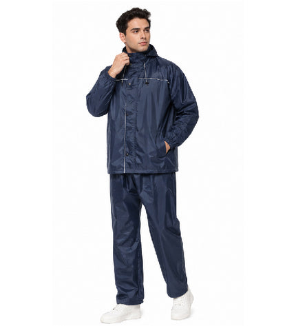 Man wearing a navy raincoat and pants on a white background