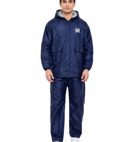 Man wearing a navy blue raincoat and pants set on a white background
