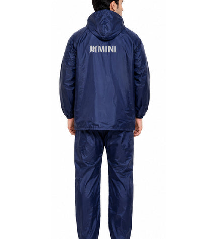 Person wearing a navy raincoat and pants with 'JCB' branding on the back, on a white background.