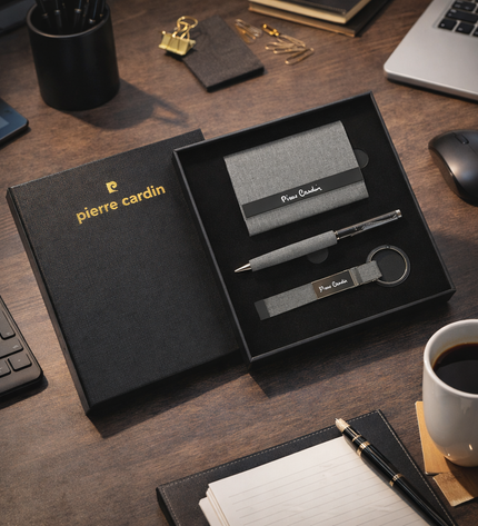 Pierre Cardin desk set with pen, keychain, and card holder on a wooden desk.