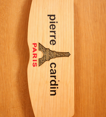 Wooden product with 'Pierre Cardin' branding on a wooden background