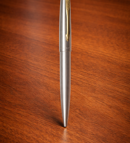 Silver pen with gold accents on a wooden surface