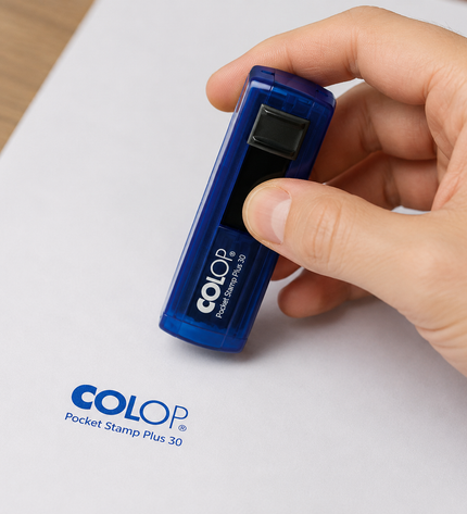 Hand holding a blue Colop Pocket Stamp Plus 30 device on a white background