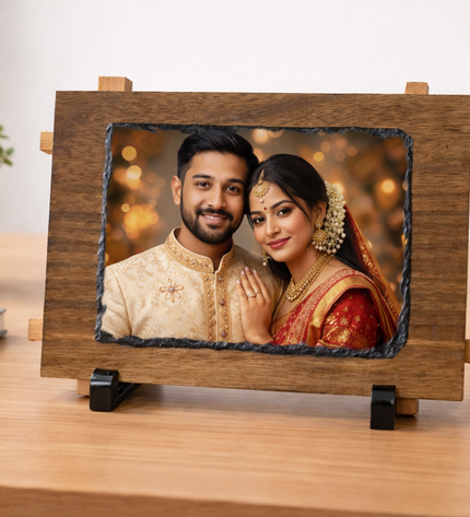 Wooden photo frame with a couple's portrait on a desk with a plant and cup in the background