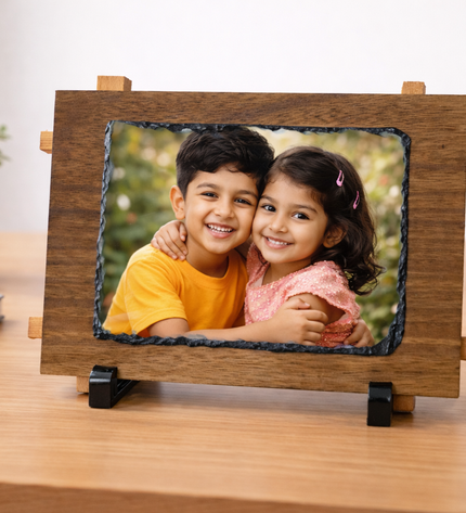 Wooden photo frame with a picture of two children on a desk.