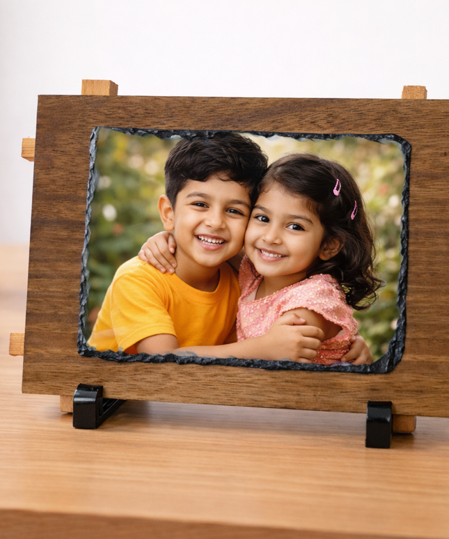Wooden photo frame with a picture of two children on a desk.