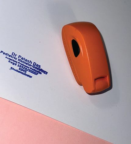 Orange rubber stamp on a white surface with blue text