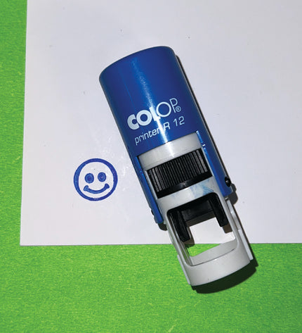 Blue Colop printer stamp on a green and white background