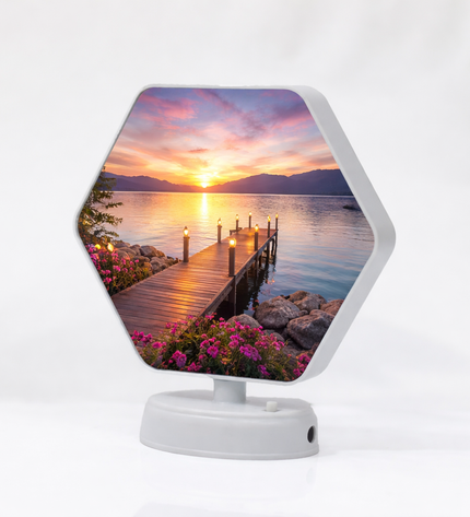 Hexagonal digital photo frame displaying a sunset over a dock scene on a white background.