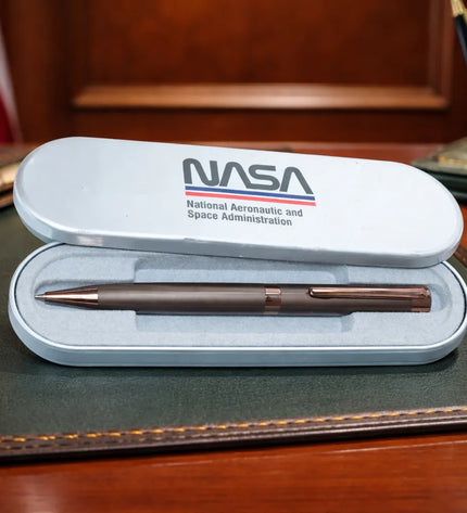 NASA pen set on a desk with an American flag in the background